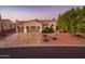 Three-car garage, desert landscaping, and well-lit driveway at 12928 W Santa Ynez Dr, Sun City West, AZ 85375