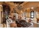 Grand living room featuring a stone fireplace, ornate chandelier, and beautiful stone columns at 16117 E Shooting Star Trl, Fountain Hills, AZ 85268