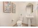 Stylish powder room with pedestal sink and patterned floor at 16884 W Pinchot Ave, Goodyear, AZ 85395