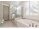 Spa-like bathroom with a large shower, soaking tub, and stylish tile at 16884 W Pinchot Ave, Goodyear, AZ 85395