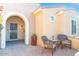 Inviting entryway with arched walkway, wrought iron security door, and patio furniture at 19937 N Turquoise Pt, Surprise, AZ 85387