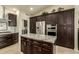 Well-equipped kitchen with dark cabinetry, granite island, and stainless steel appliances at 24008 S Lakeway Nw Cir, Sun Lakes, AZ 85248