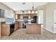 Open kitchen with island, granite counters and wood cabinets at 29864 N Desert Willow Blvd, San Tan Valley, AZ 85143
