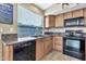 Kitchen with wood cabinets, granite counters and black appliances at 29864 N Desert Willow Blvd, San Tan Valley, AZ 85143