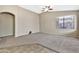 Spacious living room with neutral walls and carpet, ceiling fan, and access to other rooms at 29864 N Desert Willow Blvd, San Tan Valley, AZ 85143