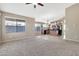 Open concept living room with kitchen and dining area, carpeted floors, and neutral walls at 29864 N Desert Willow Blvd, San Tan Valley, AZ 85143