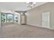 Living room with large windows, neutral decor, and a chandelier at 29864 N Desert Willow Blvd, San Tan Valley, AZ 85143