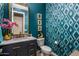 Stylish powder room with teal walls, geometric wallpaper, and marble vanity at 30248 N 115Th Dr, Peoria, AZ 85383