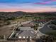 Aerial sunset view of house with pool and golf course at 319 S 227Th Ct, Buckeye, AZ 85326