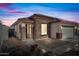 Charming one-story home with stone exterior at dusk at 319 S 227Th Ct, Buckeye, AZ 85326