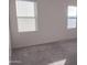 Bedroom with grey carpet and two windows at 36061 W Santa Clara Ave, Maricopa, AZ 85138