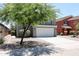 Two-story house with a white garage door and tree in front at 36521 W Padilla St, Maricopa, AZ 85138