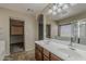 Bright bathroom showcasing a double sink vanity and a large mirror, with a walk-in closet for ample storage at 4275 E Amarillo Dr, San Tan Valley, AZ 85140