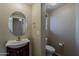Cozy half bath featuring wood vanity, round mirror, neutral paint, and tile floors at 4275 E Amarillo Dr, San Tan Valley, AZ 85140