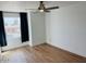 Cozy bedroom featuring wood-look flooring, natural light from the window, and modern ceiling fan at 5012 E Blanche Dr, Scottsdale, AZ 85254