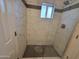 Stylish shower with marble-style tiles, a built-in shelf, and elegant fixtures at 5301 W Cambridge Ave, Phoenix, AZ 85035