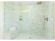 Walk-in shower with white tile, gold fixtures, and built-in seat at 8311 E Angus Dr, Scottsdale, AZ 85251