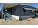 Mobile home with carport, ramp, and landscaped yard at 9501 E Broadway Rd # 107, Mesa, AZ 85208