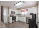 Bright kitchen with white cabinets, stainless steel appliances and wood-look flooring at 10620 W Clair Dr, Sun City, AZ 85351