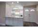 Modern kitchen with white cabinets, island, and new flooring at 10620 W Clair Dr, Sun City, AZ 85351