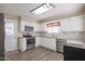 Clean kitchen with white cabinets, stainless steel appliances, and wood-look floors at 10620 W Clair Dr, Sun City, AZ 85351