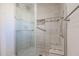 Walk-in shower with glass enclosure, tiled walls, and built-in seat at 10620 W Clair Dr, Sun City, AZ 85351