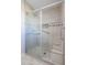 Walk-in shower with glass enclosure, tiled walls, and built-in seat at 10620 W Clair Dr, Sun City, AZ 85351