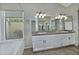 Primary bathroom with double vanity, large mirror, and bathtub at 10934 E Becker Ln, Scottsdale, AZ 85259