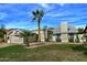 Tan house with a grassy lawn, palm tree, and attached garage at 10934 E Becker Ln, Scottsdale, AZ 85259