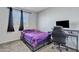 Bedroom with a purple comforter and built-in workspace at 11506 E Sylvan Ave, Mesa, AZ 85212