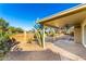 Covered patio, gravel landscaping, and cacti in sunny backyard at 11808 S Half Moon Dr, Phoenix, AZ 85044