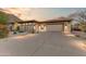 Modern desert home exterior at dusk featuring a large driveway and landscaping at 14245 N Territory Trl, Fountain Hills, AZ 85268