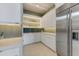 White kitchen pantry with built-in shelving and stainless steel refrigerator at 14245 N Territory Trl, Fountain Hills, AZ 85268