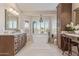 Luxurious bathroom featuring a soaking tub, separate vanity area, and shutters on the windows at 15237 S 19Th Way, Phoenix, AZ 85048