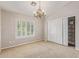 Carpeted bedroom with double closet, shelfing and a window with plantation shutters and chandelier at 15237 S 19Th Way, Phoenix, AZ 85048