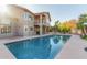 Backyard pool with patio and a two-story home featuring a balcony, palm trees, and privacy walls at 15237 S 19Th Way, Phoenix, AZ 85048