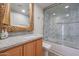 Bathroom with granite vanity, large mirror, and a shower/tub combo at 1637 W Tierra Buena Ln, Phoenix, AZ 85023