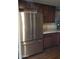 Stainless steel refrigerator in a kitchen with dark wood cabinets at 1637 W Tierra Buena Ln, Phoenix, AZ 85023