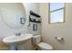 Small bathroom with pedestal sink, toilet, and window at 1647 W Gold Mine Way, San Tan Valley, AZ 85144