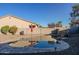 Inviting kidney shaped pool with a stone waterfall feature at 1647 W Gold Mine Way, San Tan Valley, AZ 85144