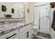 Bathroom with granite countertop, white vanity, and glass shower at 16747 W Cielo Grande Ave, Surprise, AZ 85387