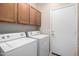 Bright laundry room, washer, dryer, and cabinets at 17528 W East Wind Ave, Goodyear, AZ 85338