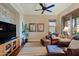 Cozy sitting area with leather chairs, a large TV, and wood floors at 17716 E Silver Sage Ln, Rio Verde, AZ 85263