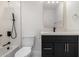 Modern bathroom with black vanity, gold fixtures, and white tile at 1936 E Cornell Dr, Tempe, AZ 85283