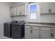 Bright laundry room with washer, dryer, and cabinets at 22034 N 59Th Pl, Phoenix, AZ 85054