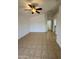 Open-concept living room with tile flooring, a ceiling fan, and access to other areas of the home at 22233 N 76Th Dr, Peoria, AZ 85383