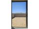 Backyard view from sliding glass door featuring a large dirt area with a tall concrete wall at 22319 W Monona Ln, Surprise, AZ 85387