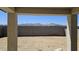 Backyard featuring a large dirt area with a tall concrete wall with scenic mountain views at 22319 W Monona Ln, Surprise, AZ 85387