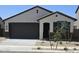 Charming single-story home featuring neutral stucco, a dark brown garage door, and desert landscaping at 22319 W Monona Ln, Surprise, AZ 85387