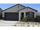 Charming single-story home featuring neutral stucco, a dark brown garage door, and desert landscaping at 22319 W Monona Ln, Surprise, AZ 85387